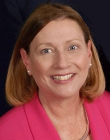 A formal professional picture of Sharon Kibbe in pink blazer 