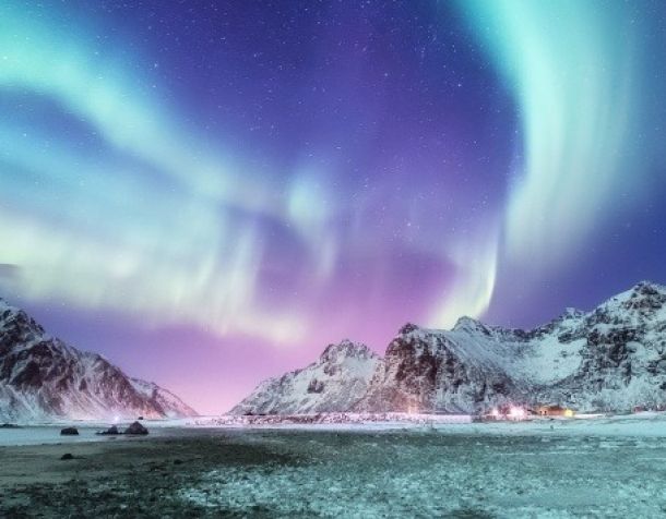 Aurora borealis on the Lofoten islands, Norway. Green northern lights above mountains. Night winter landscape with aurora. Natural background in the Norway