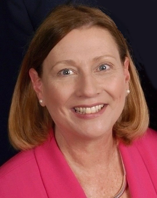 A formal professional picture of Sharon Kibbe in pink blazer 