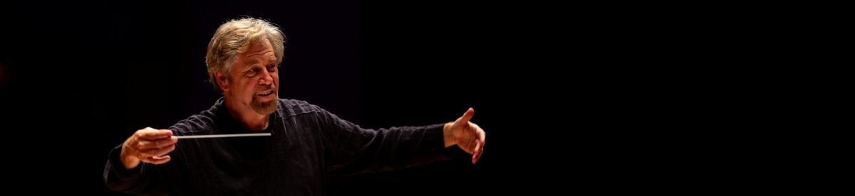 David Commanday at rehearsal conducting against black background