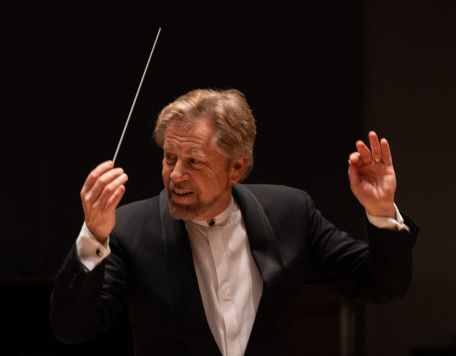 David Commanday conducting on stage in a tuxedo - close up